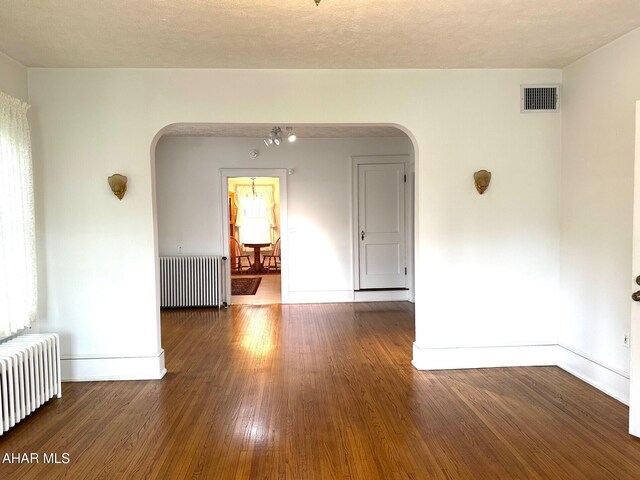 132 S Thomas St, Bedford, PA 15522 - spare room with radiator, arched walkways, and wood finished floors