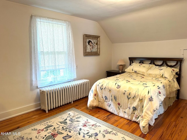 132 S Thomas St, Bedford, PA 15522 - bedroom featuring radiator heating unit, vaulted ceiling, and hardwood / wood-style flooring