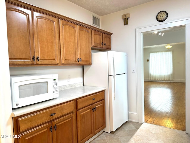 132 S Thomas St, Bedford, PA 15522 - kitchen with white appliances, brown cabinets, and light countertops