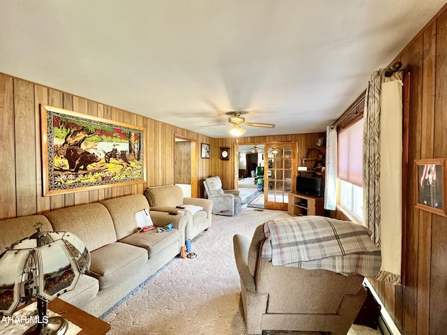 living room with ceiling fan, wood walls, light carpet, and french doors