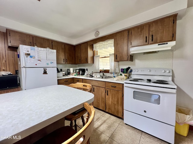 kitchen featuring light tile patterned flooring, white appliances, and sink