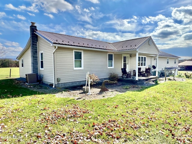 back of property with a lawn, central AC unit, and a patio