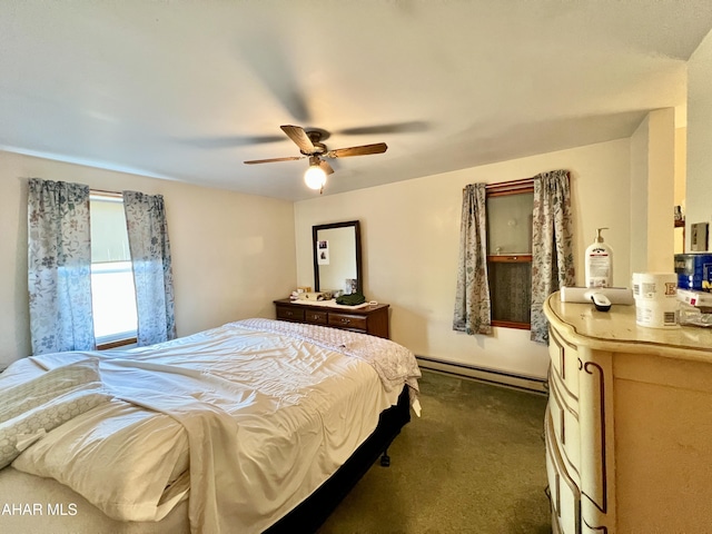 bedroom with dark colored carpet, ceiling fan, and a baseboard heating unit