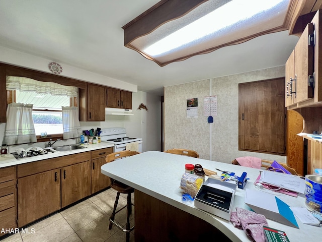 kitchen with a breakfast bar, sink, white electric stove, and light tile patterned flooring