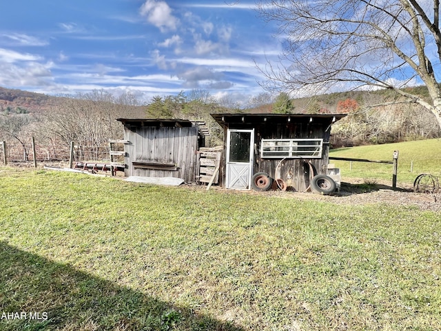 view of outdoor structure with a rural view and a yard