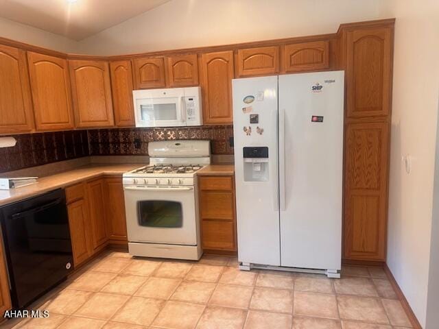 116 Estate Dr, Duncansville, PA 16635 - kitchen with white appliances, tasteful backsplash, light countertops, brown cabinetry, and lofted ceiling