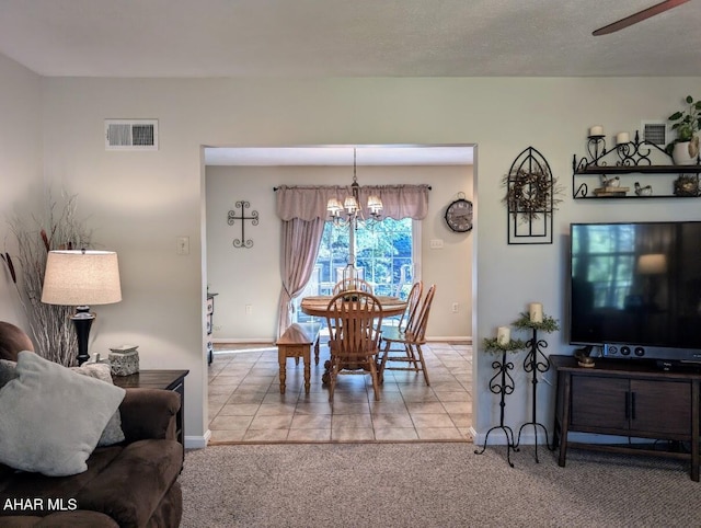 carpeted dining room featuring ceiling fan with notable chandelier