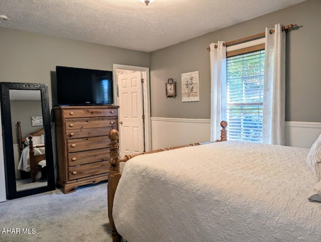 bedroom featuring light carpet and a textured ceiling