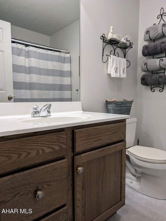 bathroom with vanity, a textured ceiling, and toilet