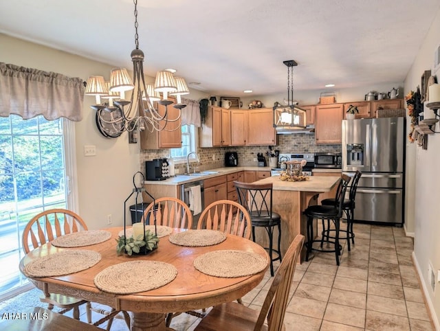 tiled dining room with sink and a chandelier