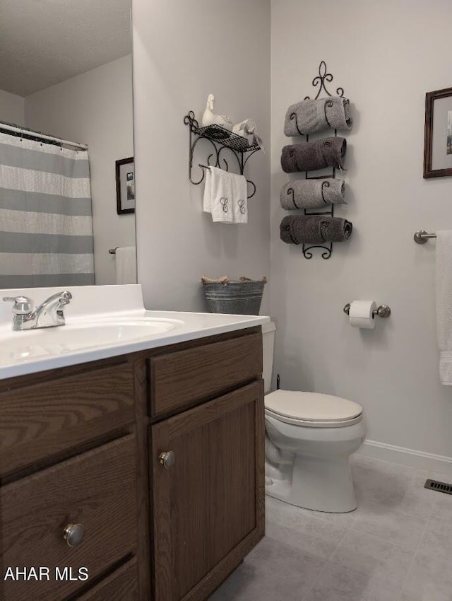 bathroom with vanity, a textured ceiling, and toilet