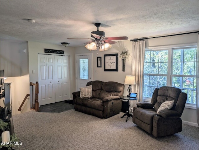 carpeted living room featuring ceiling fan, plenty of natural light, and a textured ceiling