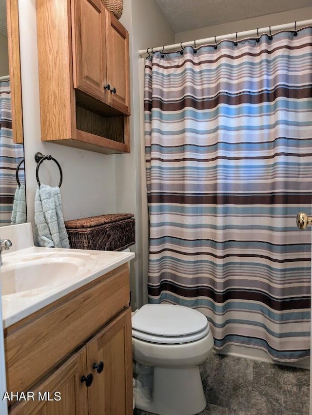 bathroom featuring a textured ceiling, vanity, toilet, and a shower with curtain