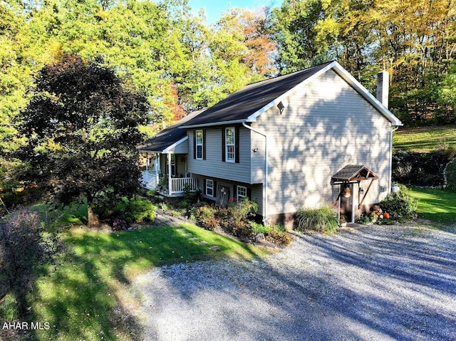 view of home's exterior with a lawn and covered porch