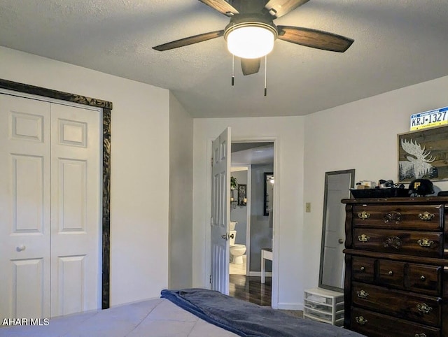 bedroom with ensuite bathroom, a textured ceiling, ceiling fan, hardwood / wood-style flooring, and a closet