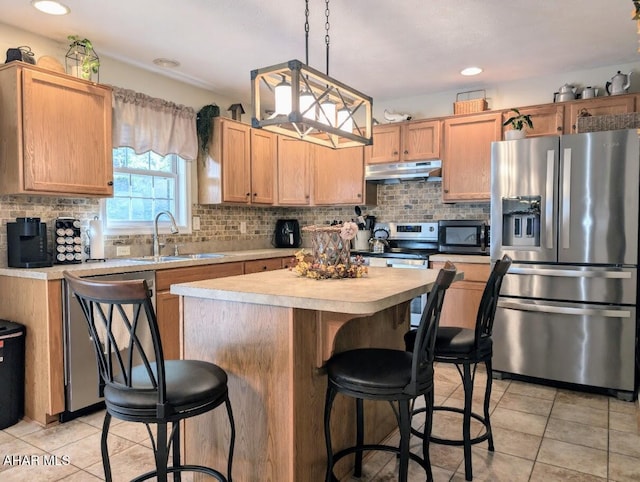 kitchen featuring sink, hanging light fixtures, stainless steel appliances, light tile patterned floors, and a kitchen island