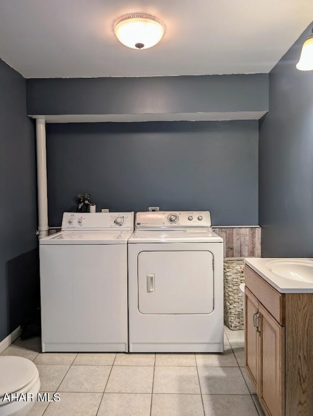 clothes washing area featuring light tile patterned floors, sink, and washing machine and clothes dryer