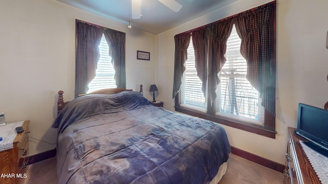 carpeted bedroom with a ceiling fan and baseboards