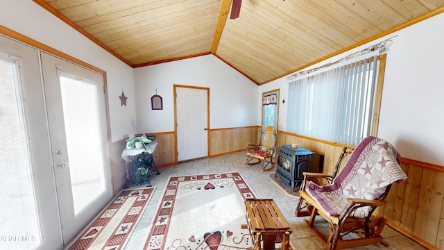 sitting room with a wainscoted wall, wooden ceiling, wooden walls, and vaulted ceiling