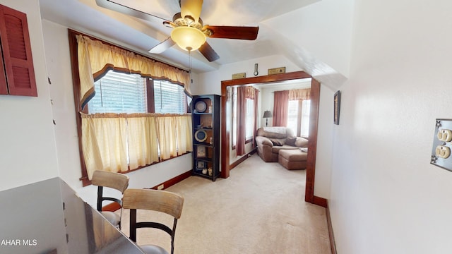 interior space featuring light colored carpet, a ceiling fan, and baseboards