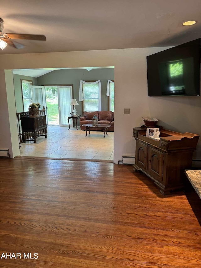 living room with ceiling fan, light hardwood / wood-style flooring, and a baseboard radiator