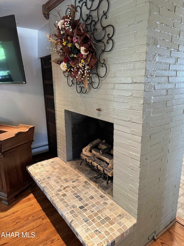 room details featuring hardwood / wood-style flooring, a fireplace, and a baseboard radiator