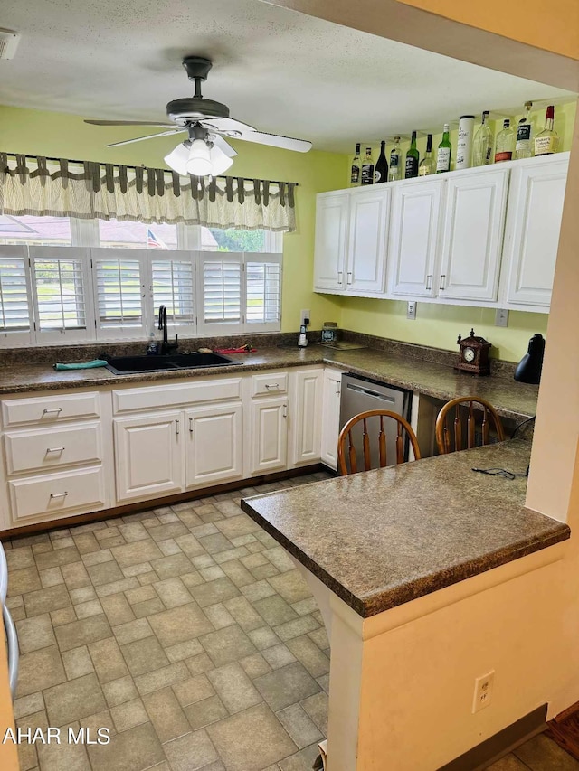 kitchen with white cabinets, a healthy amount of sunlight, kitchen peninsula, and sink