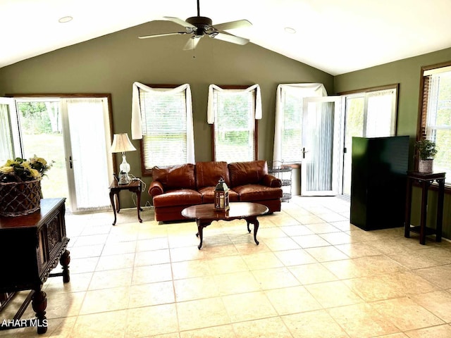 tiled living room featuring ceiling fan, a wood stove, and vaulted ceiling