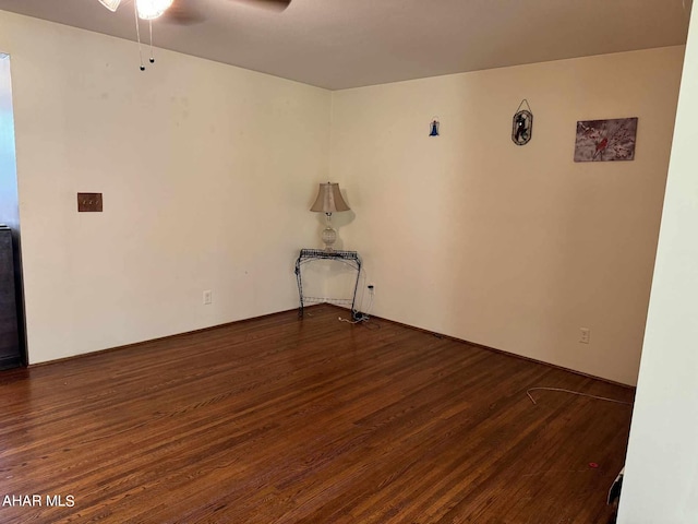 spare room with dark hardwood / wood-style flooring and ceiling fan