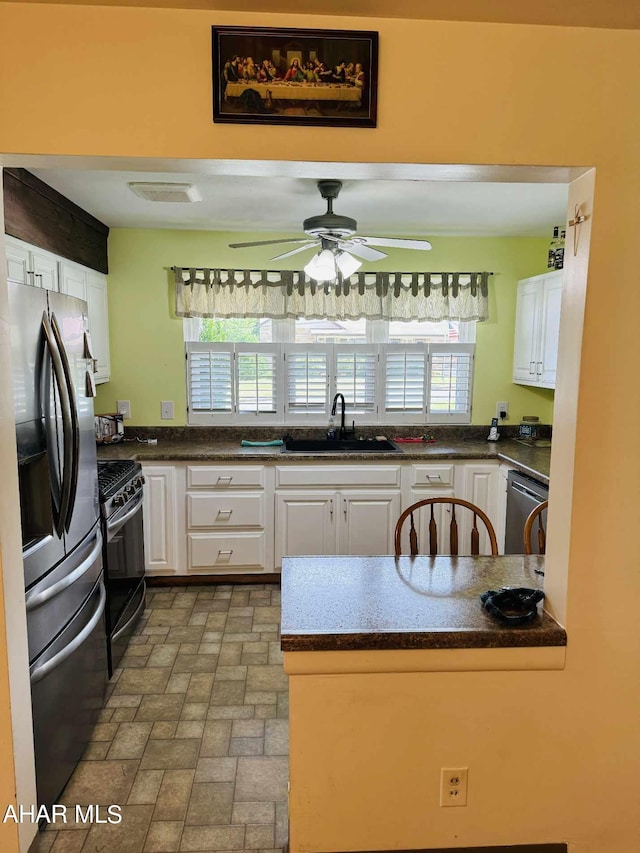 kitchen with appliances with stainless steel finishes, white cabinetry, a healthy amount of sunlight, and sink