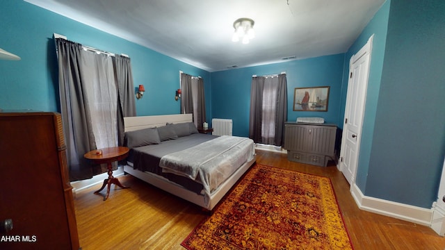 bedroom with light hardwood / wood-style flooring and radiator