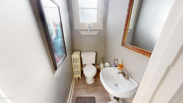 bathroom featuring radiator heating unit, sink, toilet, and hardwood / wood-style floors