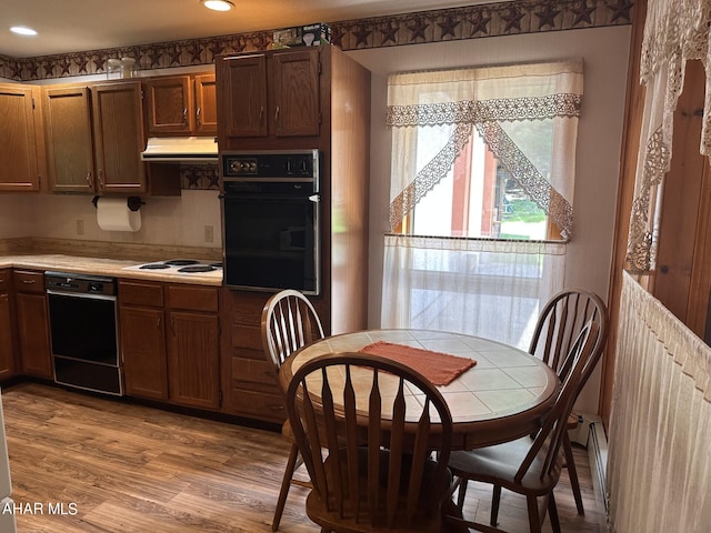 kitchen featuring black appliances and light hardwood / wood-style flooring