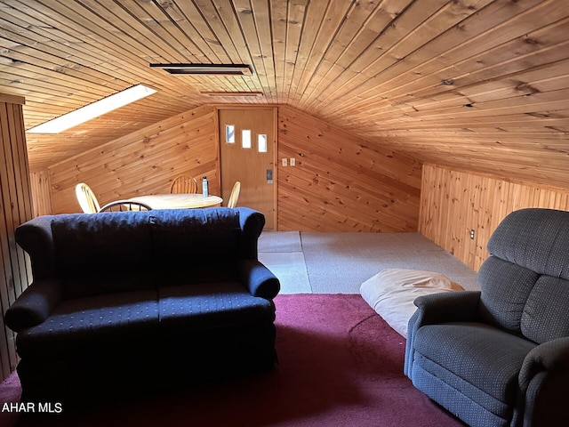 sitting room featuring wood ceiling, wooden walls, and vaulted ceiling with skylight