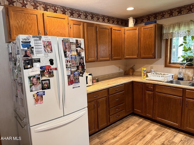 kitchen featuring white fridge, light hardwood / wood-style flooring, and sink