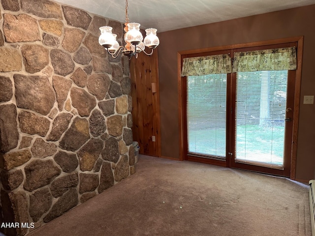 unfurnished living room with carpet flooring, a textured ceiling, a baseboard radiator, and a chandelier