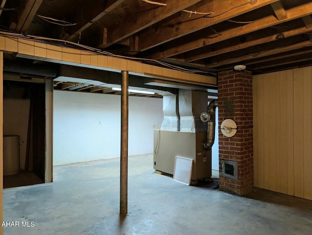 basement with wood walls and heating unit