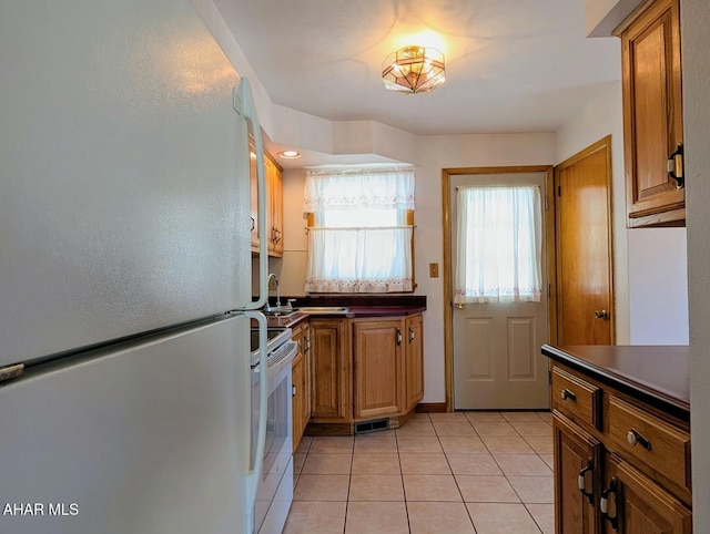 kitchen with white appliances and light tile patterned floors