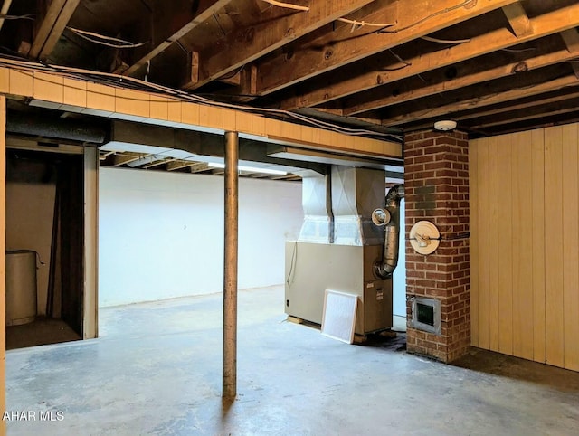 basement with wood walls and heating unit