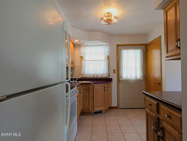 kitchen with white appliances and light tile patterned floors