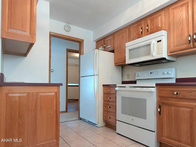 kitchen with light tile patterned floors and white appliances