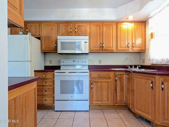 kitchen with light tile patterned flooring, white appliances, and sink