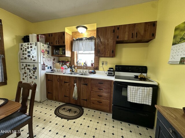 3785 Brumbaugh Rd, New Enterprise, PA 16664 - kitchen with black range with electric stovetop, freestanding refrigerator, light flooring, and light countertops