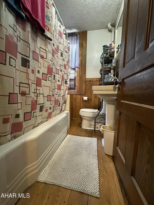 3785 Brumbaugh Rd, New Enterprise, PA 16664 - full bath with a textured ceiling, a wainscoted wall, wood finished floors, shower / bath combo with shower curtain, and wood walls