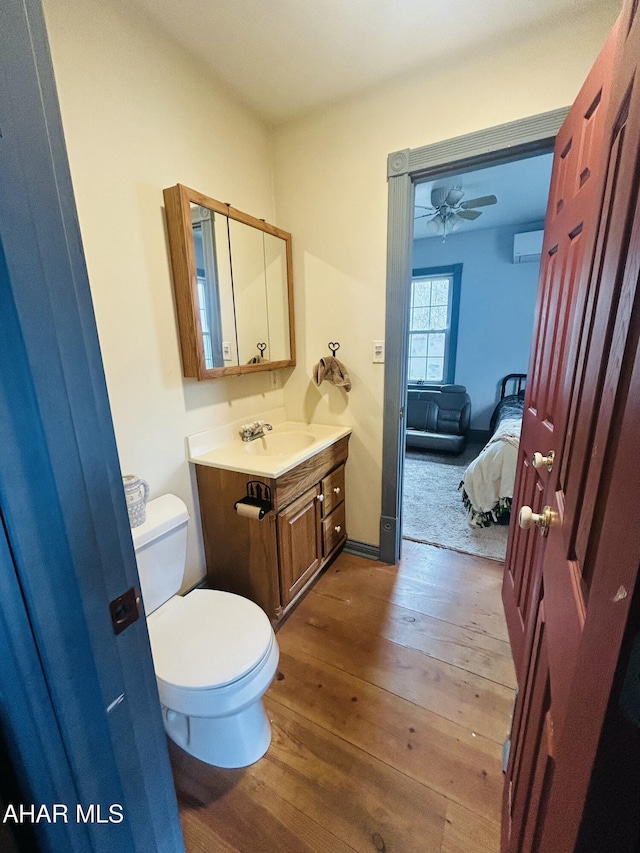 217 Good Shepherd Rd, Altoona, PA 16601 - half bathroom featuring wood-type flooring, toilet, vanity, a wall mounted AC, and connected bathroom