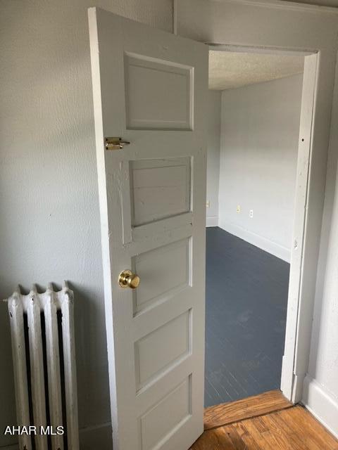 room details featuring hardwood / wood-style floors and radiator heating unit