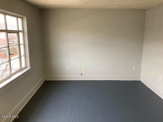 unfurnished room with a textured ceiling