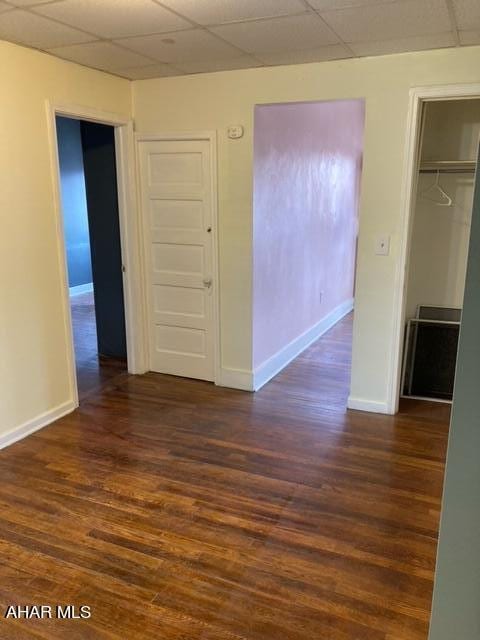 interior space featuring dark hardwood / wood-style flooring, a closet, and a drop ceiling