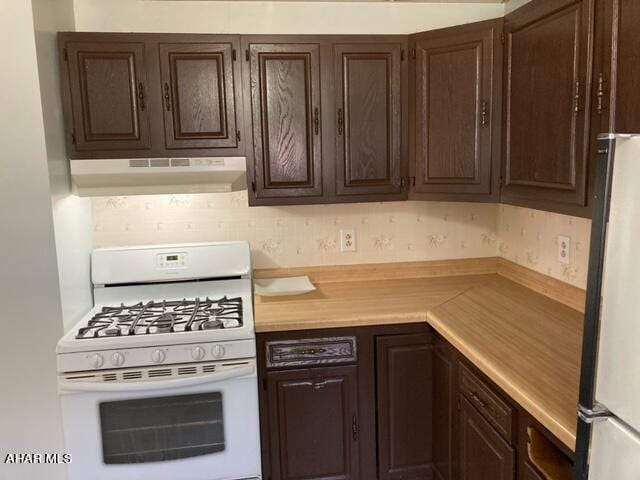 kitchen featuring dark brown cabinets and white appliances