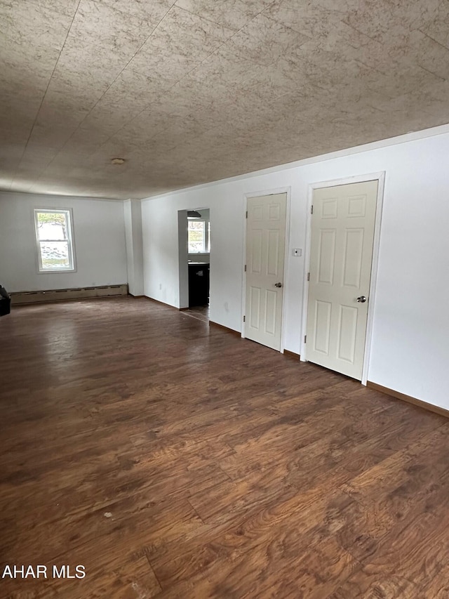 spare room featuring dark hardwood / wood-style floors and a baseboard heating unit